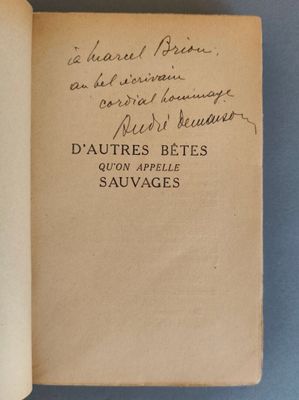 un livre ouvert, sur lequel on peut lire des notes manuscrites, posé sur une table