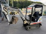 a small excavator that is parked in the parking lot