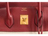a close up of a red leather bag with a gold buckle