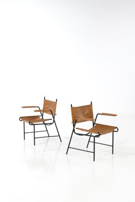 two chairs with leather seats and a metal frame on a white background