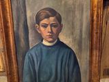 portrait d'un jeune garçon vêtu d'un pull bleu, dans un cadre doré