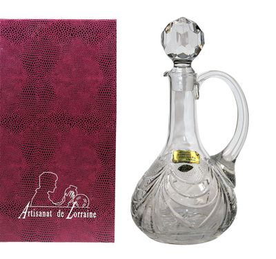 une carafe à vin en cristal, avec un chiffon rose à côté
