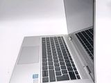a silver laptop with a black keyboard on a white table