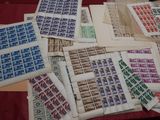 a lot of stamps on a table with a red table cloth