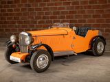 an orange car that is parked in front of a brick wall