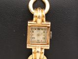 an image of a gold wrist watch with a chain around it