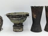 three different types of vases and a clock on a white surface