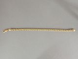 gros plan d'un bracelet en or avec une chaîne