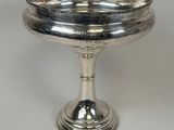 a silver plate on a pedestal on a white background
