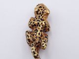 a gold and black leopard broochle on a white background