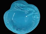 a blue plate with a mermaid on it on a black background
