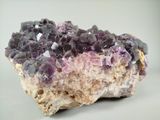 a close up of a piece of rock with purple crystals on it