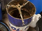 un tonneau bleu, un seau bleu et quelques autres objets posés par terre