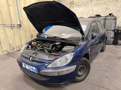 une voiture bleue dont le capot est ouvert dans un garage