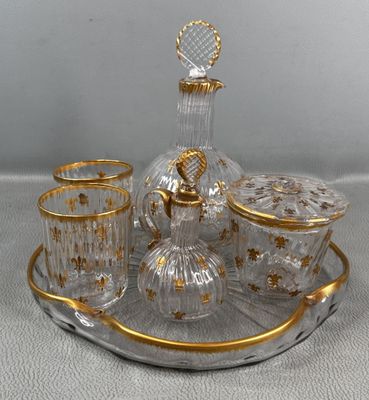 un plateau en verre sur lequel sont posés une carafe en verre et des tasses