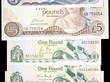 quatre billets de banque différents, de formes et de tailles variées, sur fond noir