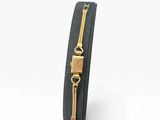 a close up of a black leather bracelet with a gold clasp