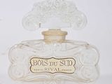 une photo d'un flacon de parfum posé sur une table blanche