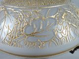 a white and gold vase with a gold design on it