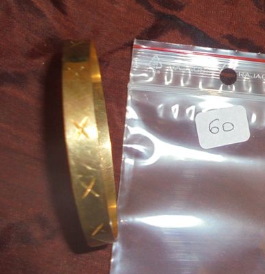 un bracelet en or et un bracelet rigide en or posés sur un tissu marron