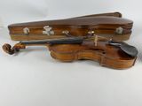 a violin sitting next to a case on a white surface