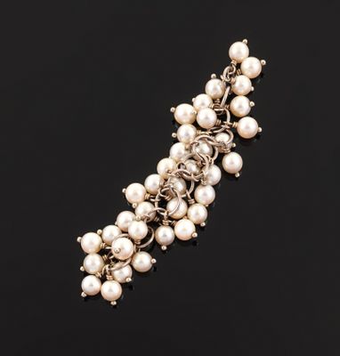 a close up of a pearl bracelet on a black surface
