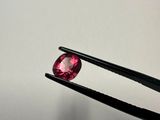 a close up of a pair of tongs holding a pink diamond
