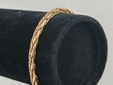 un gros plan d'une bague en or posée sur un présentoir noir