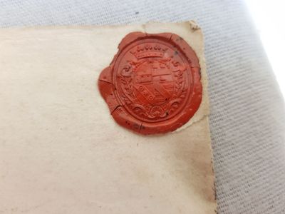 an old wax seal sitting on top of a piece of paper