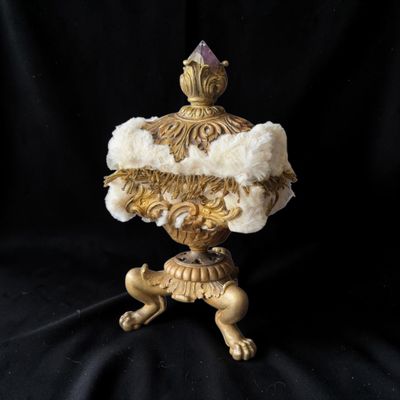 un vase doré et blanc orné de fleurs sur fond noir