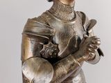 a bronze statue of a woman holding a knife
