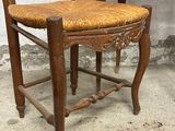 a wooden chair with a woven seat next to a desk