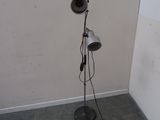 a lamp that is on a stand in the corner of a room