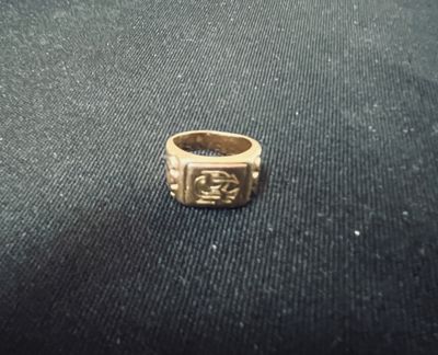 gros plan d'une bague en or sur une surface noire