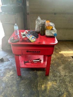 une petite table rouge sur laquelle se trouve une bouteille d'eau