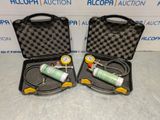 pair of air compressors in black case with yellow handles on a table