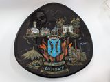 a black plate with a picture of a city on it