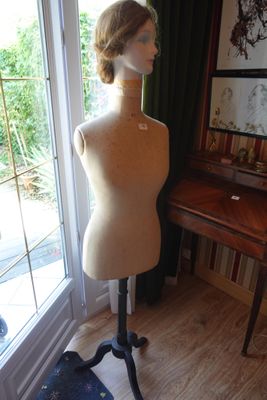 un mannequin assis sur un socle devant une vitrine