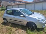 a small silver car parked in the grass in front of a building