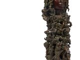 sculpture représentant le visage d'une femme dans un arbre, avec un oiseau posé sur sa tête