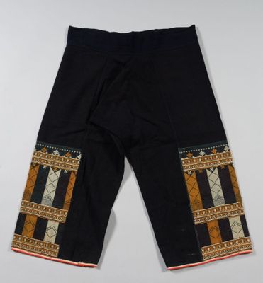 un gros plan sur un pantalon noir orné d'un motif sur le côté