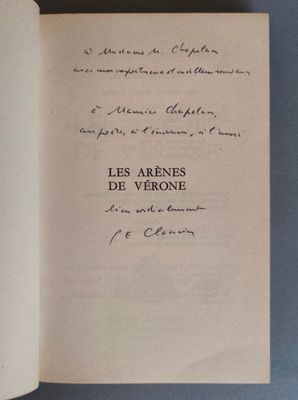 un livre ouvert posé sur une table, dont une page est écrite à la main