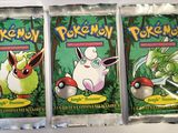 three packs of pokemon trading cards on a white surface