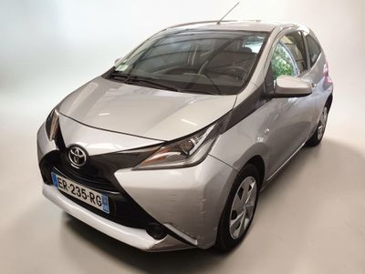 La Toyota AY est garée dans une pièce au fond blanc.