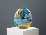 un vase en verre posé sur un socle blanc