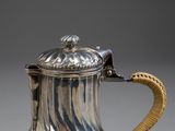 an antique silver plated coffee pot with a gold handle