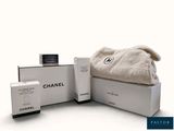 une boîte blanche sur laquelle sont posés une serviette et un flacon de parfum