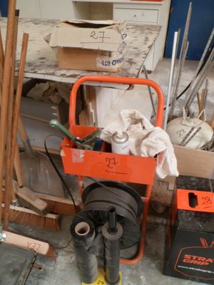 un petit chariot orange contenant des outils dans une pièce