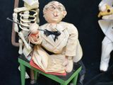 two figurines of a man and a woman sitting on a chair