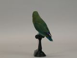 a green bird that is sitting on top of a black stand